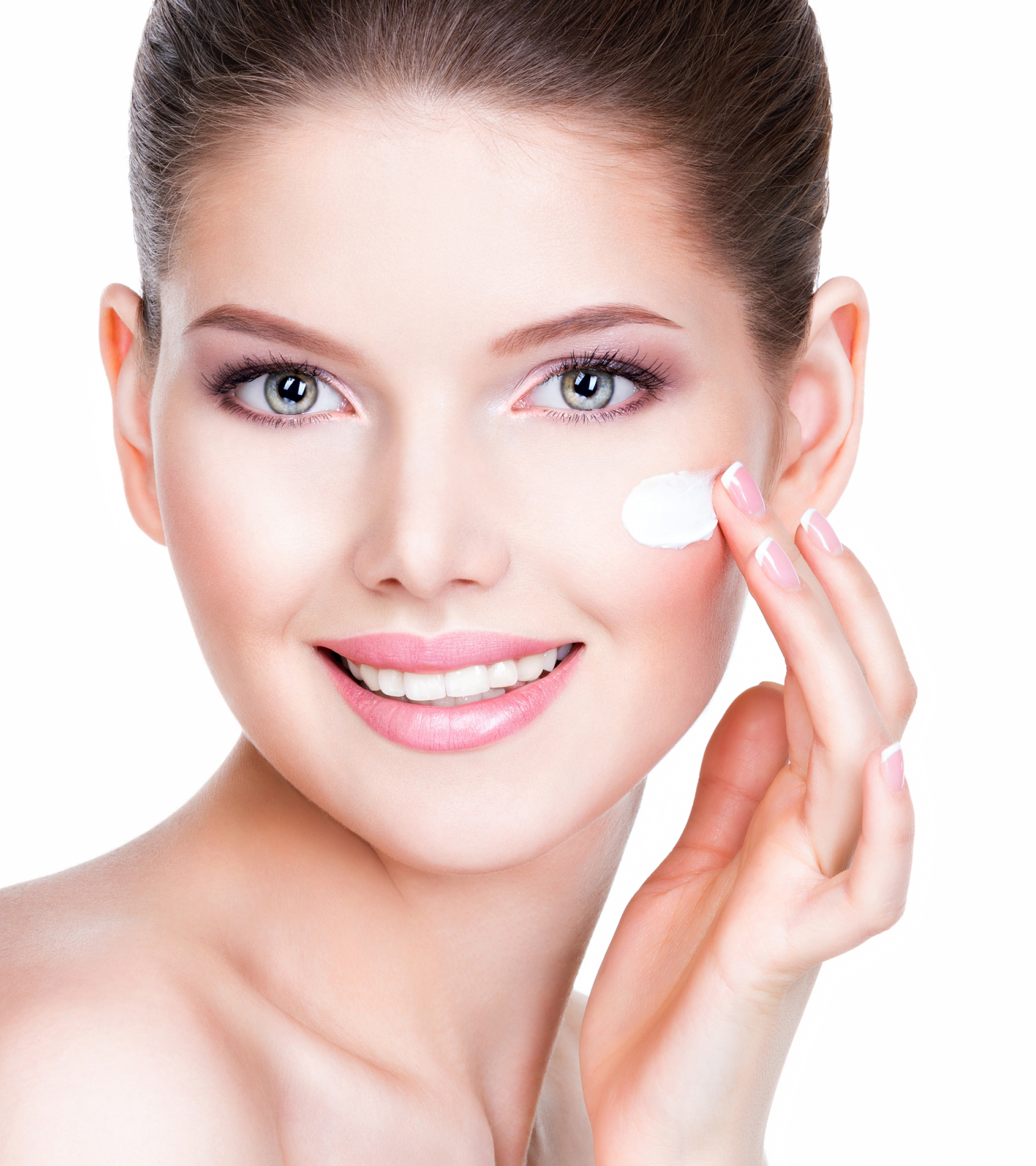 Smiling woman applying cream to her face