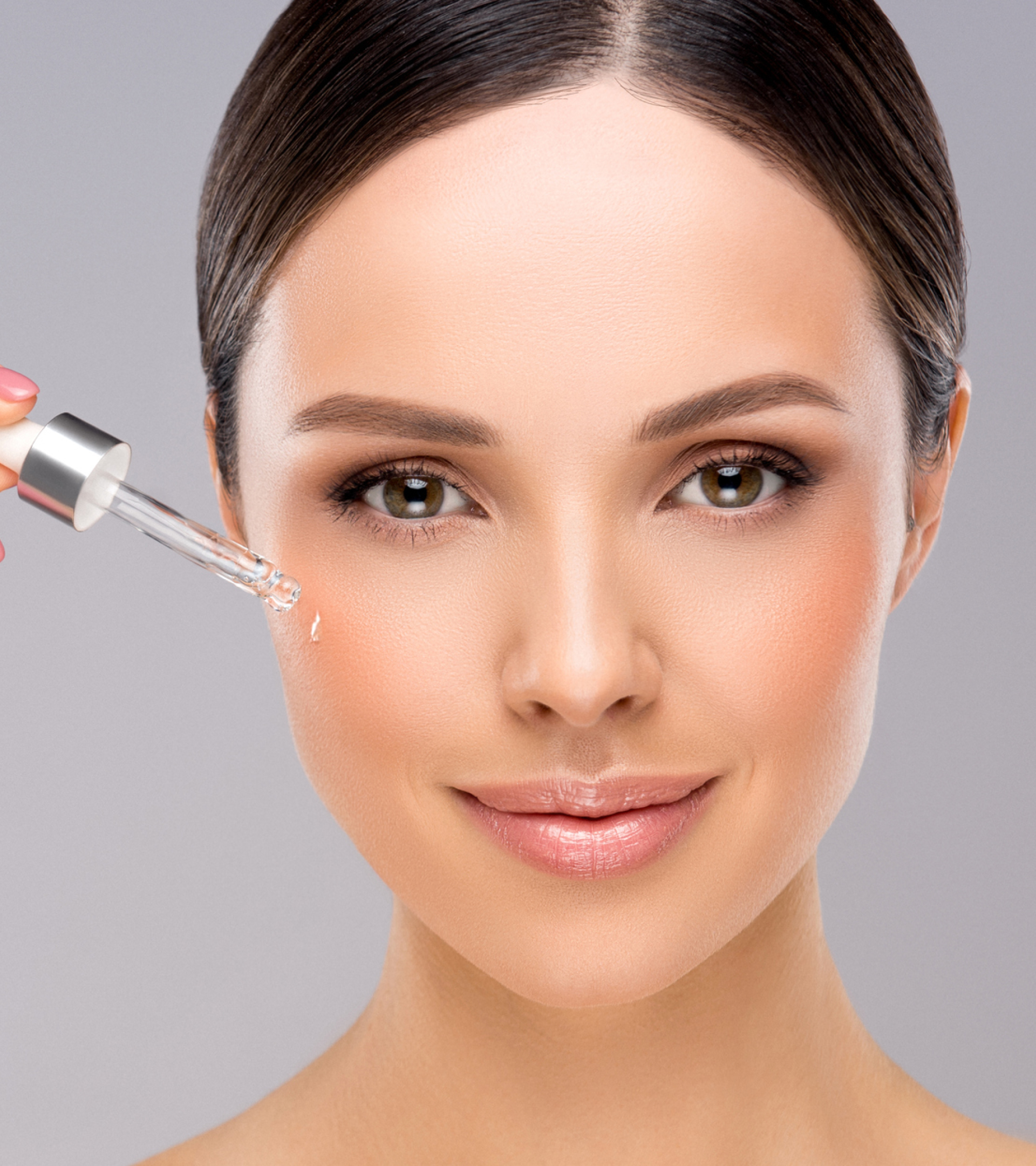 Woman applying a dropper to her face