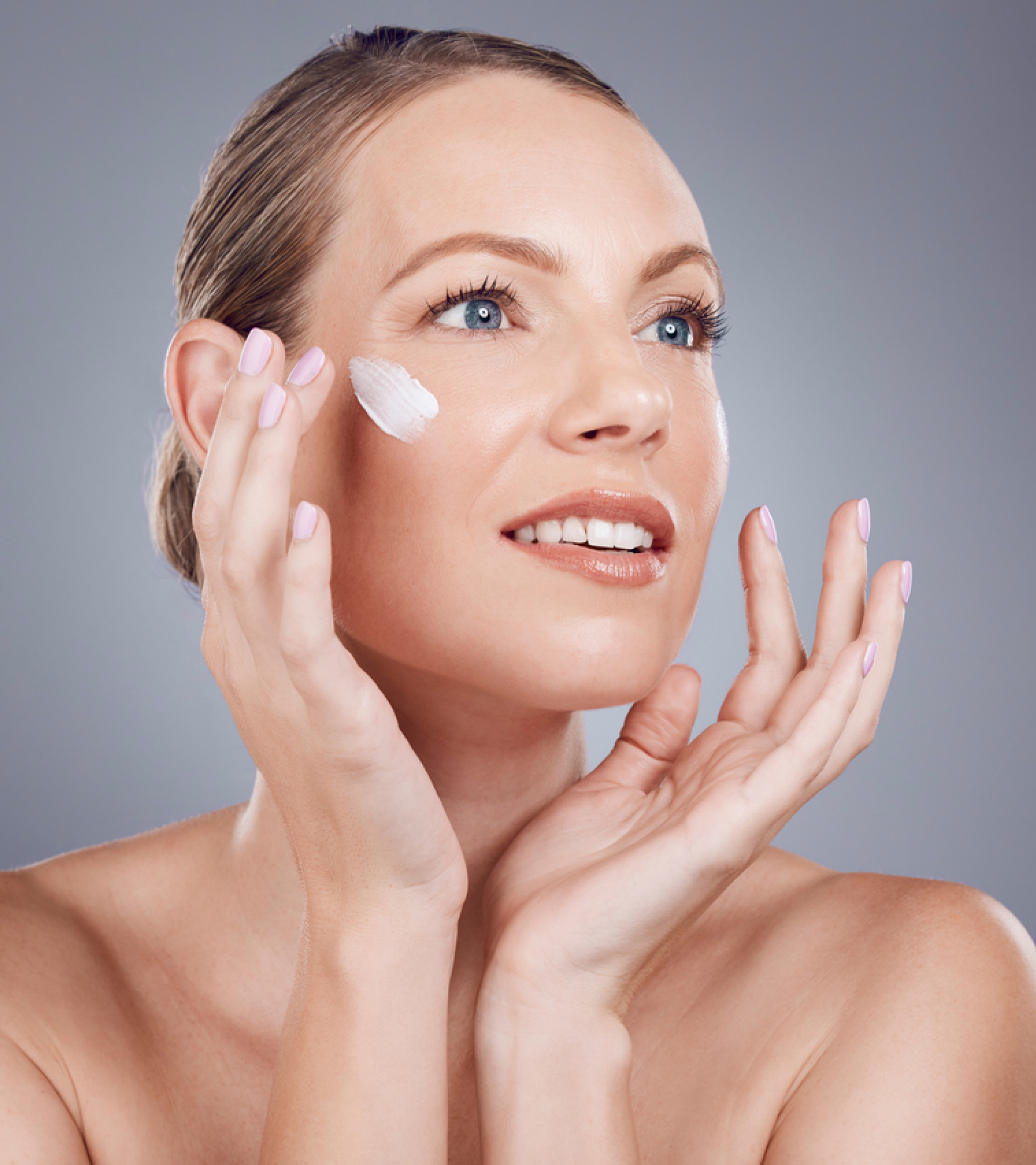 Woman applying cream to her face